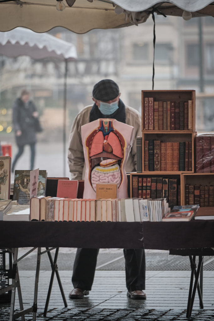 Homme debout devant table de libraire avec modèle anatomique devant lui